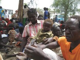 A Sudanese man (right) in Upper Nile grieves the loss of his two daughters after an airstrike on his town in Blue Nile, Sudan (UNHCR).